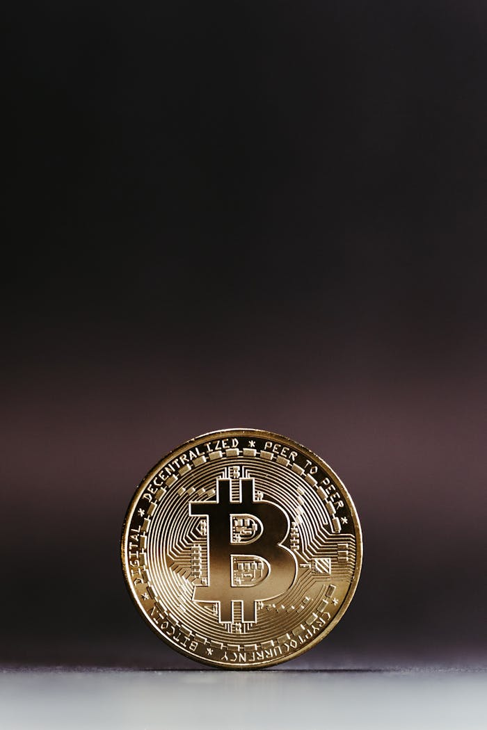 Services Close-up of a shining golden Bitcoin coin on a dark gradient background, symbolizing digital currency.