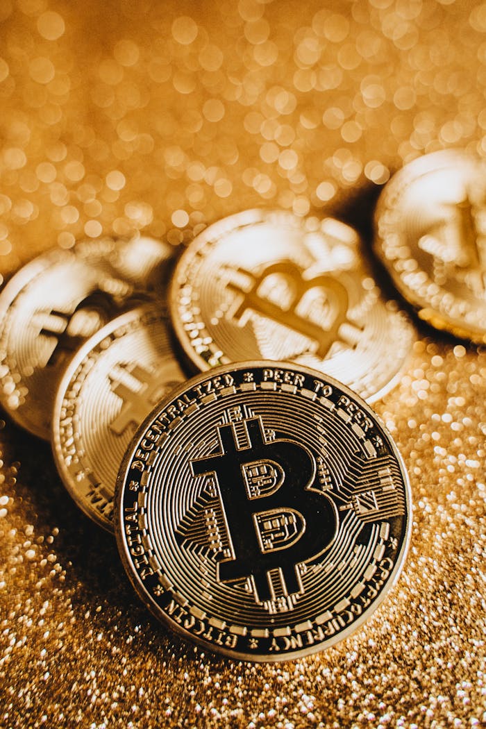 Home A close-up shot of shiny Bitcoin coins on a glittering gold surface, depicting digital currency and wealth.