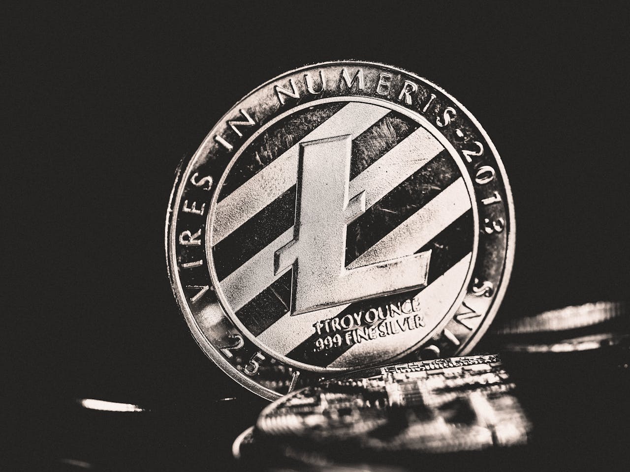 Close-up view of a Litecoin coin with intricate details in grayscale.