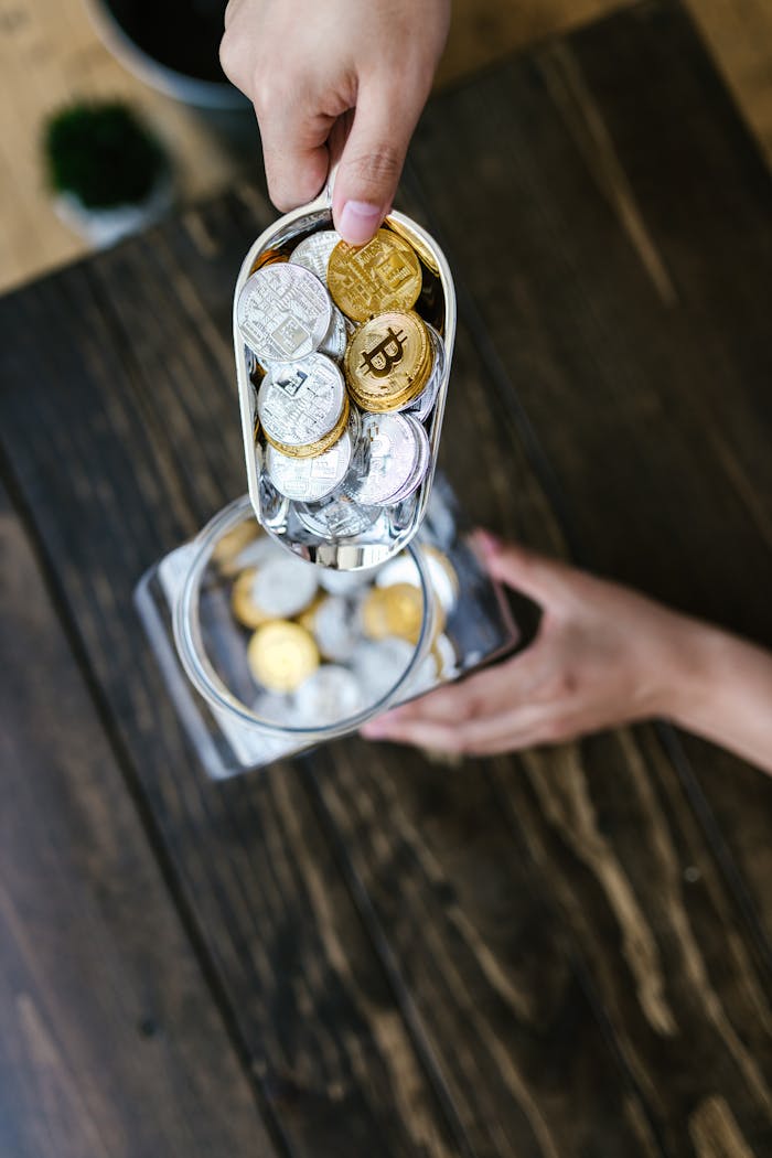 Services Hands pouring visually textured cryptocurrency coins into a transparent container.